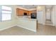 Kitchen featuring light wood cabinets, stainless sink, black refrigerator, and view to the living room at 11649 Tempest Harbor Loop, Venice, FL 34292