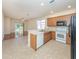Kitchen featuring light wood cabinets, stainless sink, white appliances, black fridge, and open layout at 11649 Tempest Harbor Loop, Venice, FL 34292