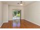 Living room featuring wood flooring, a ceiling fan, and sliding glass doors leading to the outdoor lanai at 11649 Tempest Harbor Loop, Venice, FL 34292