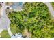 Aerial shot showing a densely wooded lot, surrounded by mature trees and greenery in a residential neighborhood at 1214 Rumson Ct, North Port, FL 34288
