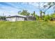 An expansive grassy backyard with a screened-in patio boasts beautiful landscaping at 1214 Rumson Ct, North Port, FL 34288