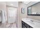 Bathroom featuring a vanity sink, mirror, and walk-out to patio at 1214 Rumson Ct, North Port, FL 34288