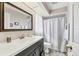 Bathroom with a vanity sink, framed mirror, and tub with shower curtain at 1214 Rumson Ct, North Port, FL 34288
