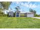 Charming single-story home with a well-manicured lawn, a metal roof, and a two-car garage at 1214 Rumson Ct, North Port, FL 34288