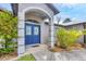 Inviting front entrance with a blue double door, manicured landscaping, and architectural details at 1214 Rumson Ct, North Port, FL 34288