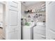 This laundry room has white appliances, shelves, a door, and tile floors at 1214 Rumson Ct, North Port, FL 34288