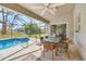 The screened-in patio has wicker chairs, a glass table, tile floors, and a view of the pool at 1214 Rumson Ct, North Port, FL 34288