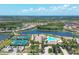 Stunning aerial view of a community showcasing a large pool, tennis courts, and beautiful landscaping near a lake at 12370 Canavese Ln, Venice, FL 34293