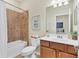 Well-lit bathroom boasts a tub and shower combination with decorative vanity and large mirror at 12370 Canavese Ln, Venice, FL 34293