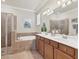 Spacious bathroom with double sinks, a soaking tub, and a glass-enclosed shower at 12370 Canavese Ln, Venice, FL 34293