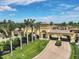 Beautifully landscaped community entrance featuring palm trees and an elegant architectural design on a sunny day at 12370 Canavese Ln, Venice, FL 34293