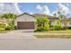 Charming single-story home with a well-manicured lawn, mature landscaping, and a brown tile roof at 12370 Canavese Ln, Venice, FL 34293