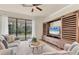 Comfortable living room with a large window, cozy seating, and stylish entertainment center at 12370 Canavese Ln, Venice, FL 34293