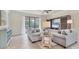 Comfortable living room with a large window, cozy seating, and stylish entertainment center at 12370 Canavese Ln, Venice, FL 34293