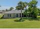 This backyard boasts a lush green lawn, mature trees, and partial view of the screened lanai at 1240 Lucaya Ave, Venice, FL 34285