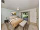 Staged bedroom with ceiling fan, slider glass door access to the patio, and a decorative rug at 1240 Lucaya Ave, Venice, FL 34285