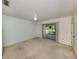 Bright bedroom with neutral carpet, ceiling fan, and sliding doors to screened porch overlooking yard at 1240 Lucaya Ave, Venice, FL 34285