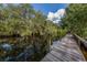 Wooden dock on a river with dark water surrounded by lush trees at 1240 Lucaya Ave, Venice, FL 34285