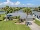Beautiful single-story home with a two-car garage and lush green lawn with mature palm trees at 1240 Lucaya Ave, Venice, FL 34285