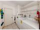 Laundry room with white tile floors, storage shelves, a washing machine, and a dryer at 1240 Lucaya Ave, Venice, FL 34285