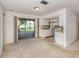 Open floor plan shows the dining and kitchen area with neutral carpet, sliding glass door with views of the lake at 1240 Lucaya Ave, Venice, FL 34285
