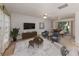 Staged living room with neutral carpet, white walls, and contemporary furniture at 1240 Lucaya Ave, Venice, FL 34285