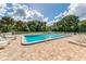 Large community pool with ladders and lounge chairs and lush trees at 1240 Lucaya Ave, Venice, FL 34285