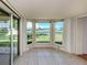 Bright sunroom with tiled floor, bay window, and glass slider overlooking scenic lake view at 1240 Lucaya Ave, Venice, FL 34285