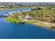 Aerial view of a picturesque lake community featuring walking paths, lush greenery, and a charming pier extending into the water at 12440 Wellen Golf St # 204, Venice, FL 34293