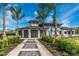 Inviting clubhouse exterior with covered awnings, lush landscaping, and adjacent tennis court at 12440 Wellen Golf St # 204, Venice, FL 34293