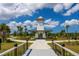 Beautiful clubhouse entrance featuring a covered tower and elegant landscaping, perfect for community gatherings and events at 12440 Wellen Golf St # 204, Venice, FL 34293