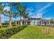 Beautiful clubhouse exterior with covered awnings, lush landscaping, and convenient parking at 12440 Wellen Golf St # 204, Venice, FL 34293