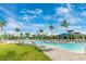 Resort-style pool area with lounge chairs, beautiful landscaping, and outdoor seating under a clear sky at 12440 Wellen Golf St # 204, Venice, FL 34293