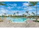 Stunning community pool with clear blue water, lounge chairs, and resort-style amenities under a partly cloudy sky at 12440 Wellen Golf St # 204, Venice, FL 34293
