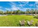 Inviting outdoor community space with well-manicured lawn, tennis court and comfortable seating area at 12440 Wellen Golf St # 204, Venice, FL 34293