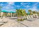 Inviting outdoor community space with lounge chairs and shaded cabanas amidst mature landscaping at 12440 Wellen Golf St # 204, Venice, FL 34293