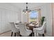 Bright dining area featuring a rustic wood table with white upholstered chairs and views of the golf course at 12440 Wellen Golf St # 204, Venice, FL 34293