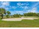 Picturesque golf course view with a sand trap in the foreground and lush green fairways in the background at 12440 Wellen Golf St # 204, Venice, FL 34293