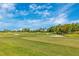 Lush golf course featuring undulating greens, sand traps, and manicured fairways under a partly cloudy sky at 12440 Wellen Golf St # 204, Venice, FL 34293