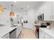 The bright kitchen features white cabinets, stainless appliances, and a large island with counter seating at 12440 Wellen Golf St # 204, Venice, FL 34293