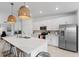 Bright kitchen features a large island, stainless steel appliances, and stylish woven pendant lighting at 12440 Wellen Golf St # 204, Venice, FL 34293