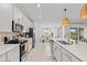 Modern kitchen with stainless steel appliances, white cabinets, and a view to the dining area at 12440 Wellen Golf St # 204, Venice, FL 34293