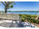 Scenic lake view from a bench surrounded by greenery and a clear blue sky for the perfect relaxation spot at 12440 Wellen Golf St # 204, Venice, FL 34293