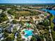 Aerial view showcases a community's pool area, surrounding homes, and lakefront location at 12689 Sagewood Dr, Venice, FL 34293