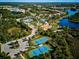 Aerial view of community amenities including tennis courts, pools, playground and lake at 12689 Sagewood Dr, Venice, FL 34293