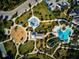 Aerial view of a community featuring a pool, splash pad, and playground surrounded by palm trees and green spaces at 12689 Sagewood Dr, Venice, FL 34293