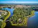 An aerial view of a community nestled around a tranquil lake and lush greenery, offering a serene and picturesque setting at 12689 Sagewood Dr, Venice, FL 34293