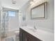 Bright bathroom featuring a white vanity, large mirror, and a bathtub with a shower at 12689 Sagewood Dr, Venice, FL 34293