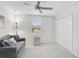 Cozy bedroom with a comfortable sofa, a ceiling fan, and a bright window at 12689 Sagewood Dr, Venice, FL 34293