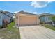Well-maintained two-car garage with a paved driveway, complemented by manicured landscaping and a welcoming facade at 12689 Sagewood Dr, Venice, FL 34293